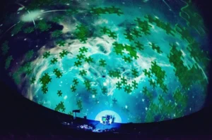 A large projection of the sky with green puzzle pieces.